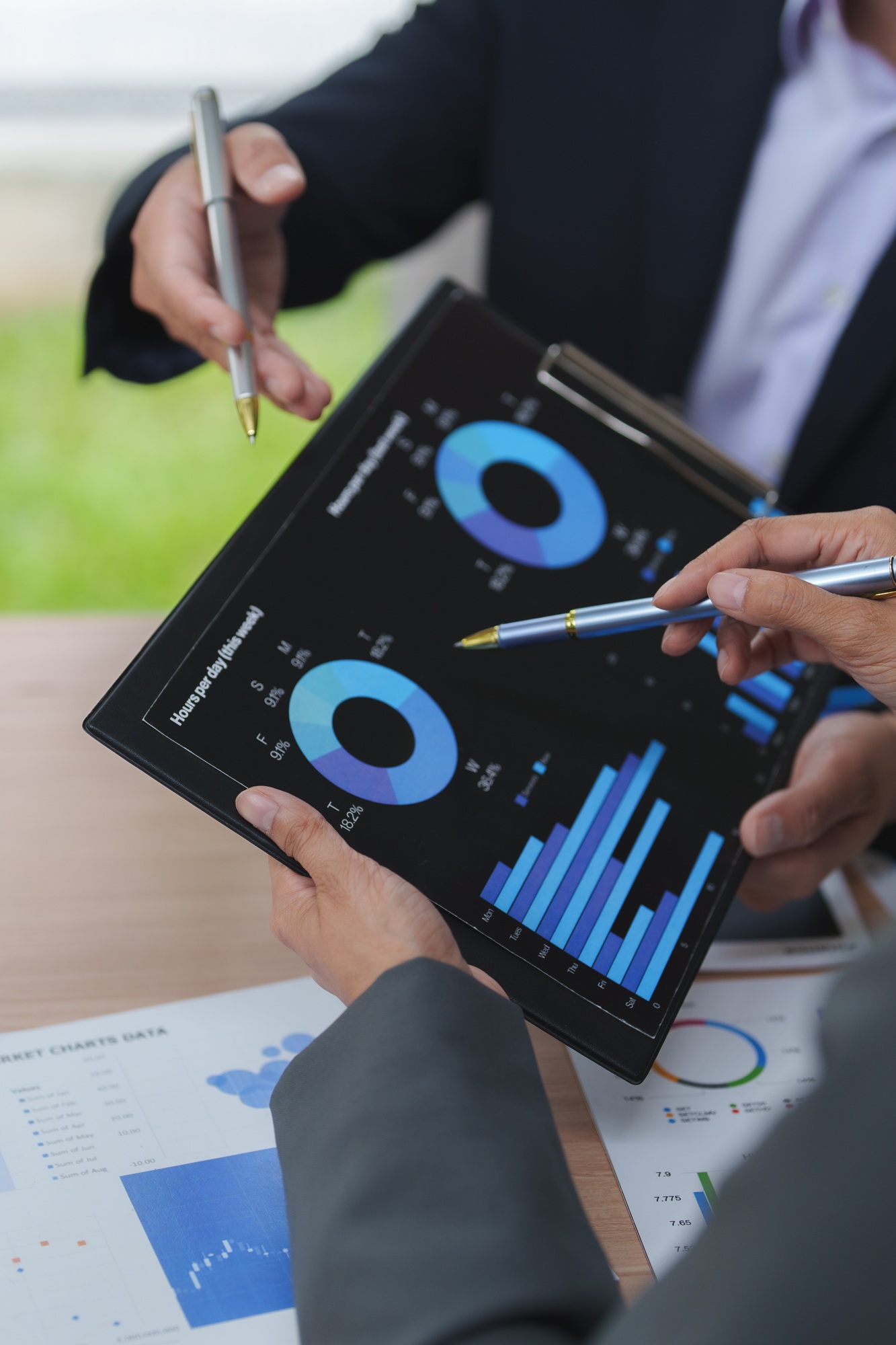Business people analyzing financial charts and data on tablet